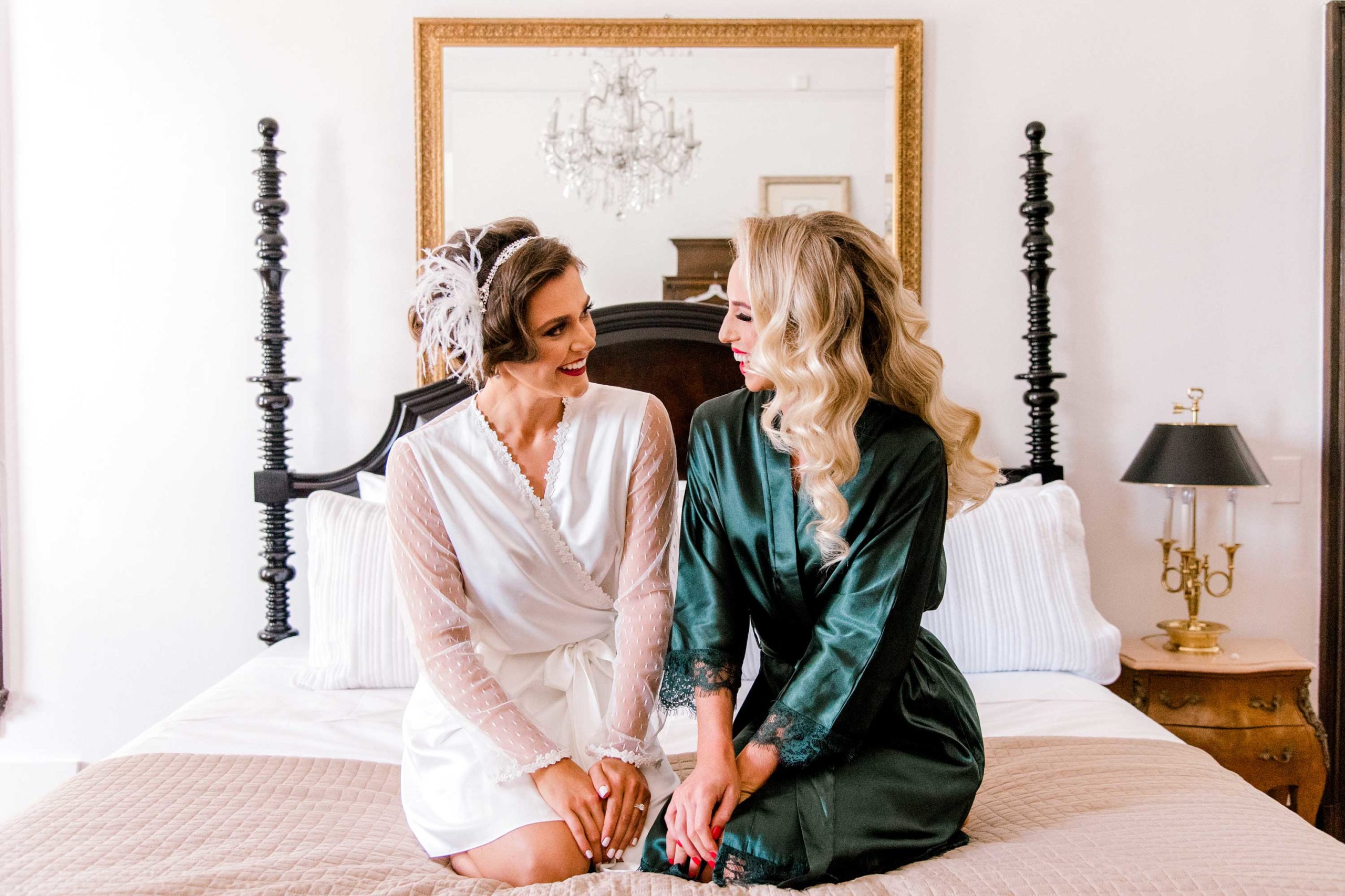 Bride and Maid of Honor sitting in bed smiling